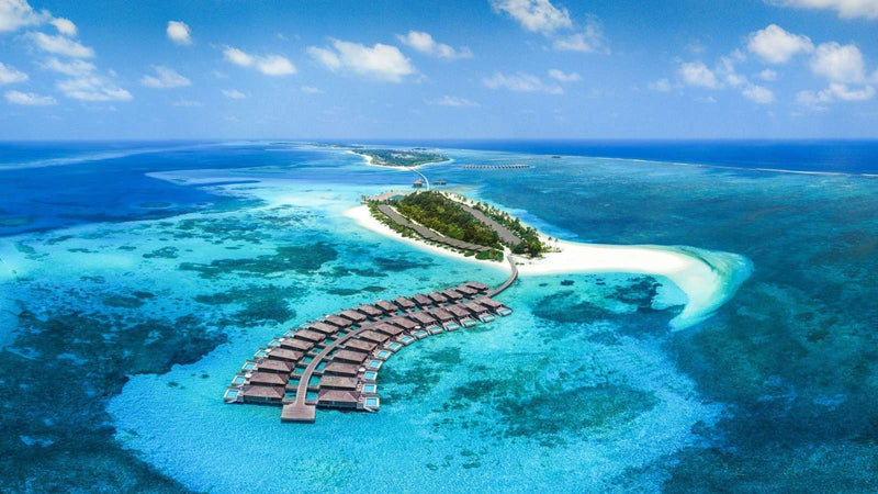 Jawakara Islands Maldives, Lhaviyani Atoll: aerial view of a row of overwater villas with the reef around the turquoise lagoon