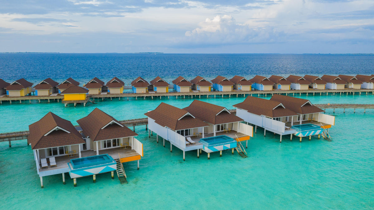 The Standard Huruvalhi Maldives, overwater villas with coloured awnings above turquoise water