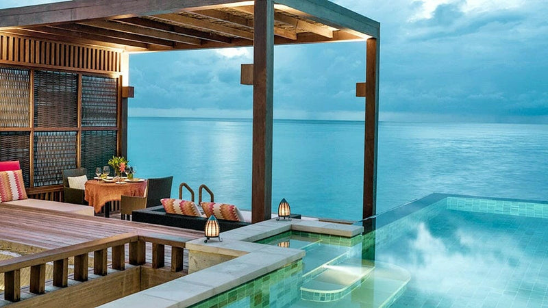An overwater deck at Four Seasons Kuda Huraa, a pool set at its edge and open to the sea
