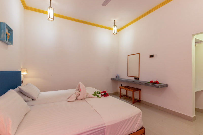 Room at Dream Inn Thulusdhoo with white walls, hanging lanterns, a blue headboard and a mirror above a wall shelf