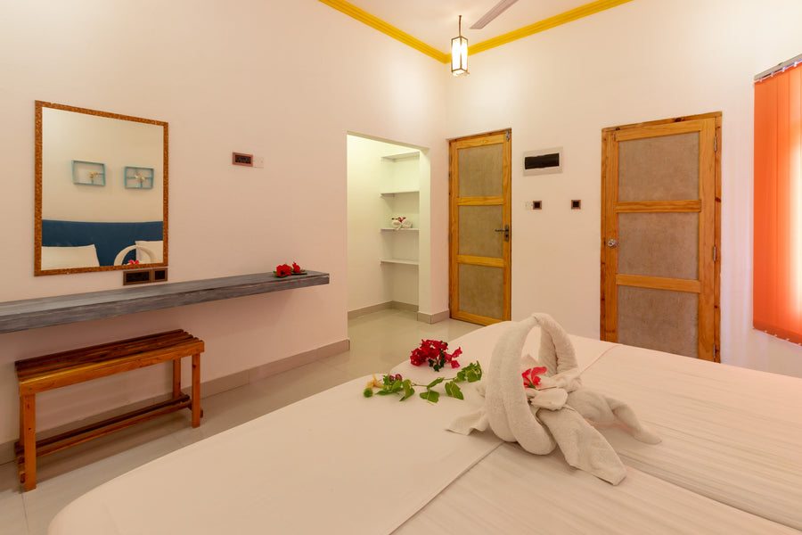 Room at Dream Inn Thulusdhoo with a wooden bench, wall mirror and shelf, and doors to a walk-through wardrobe area