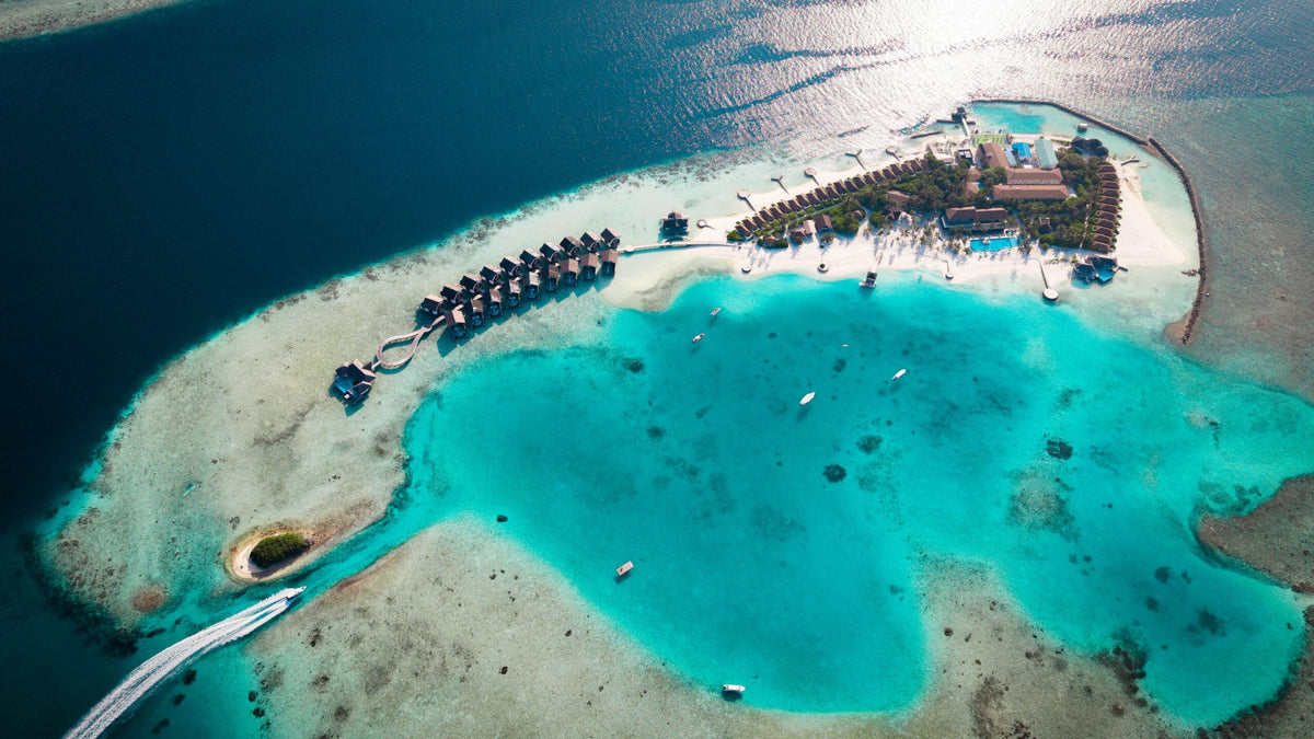 NOOE Maldives Kunaavashi from the air, the island, lagoon and overwater villas.