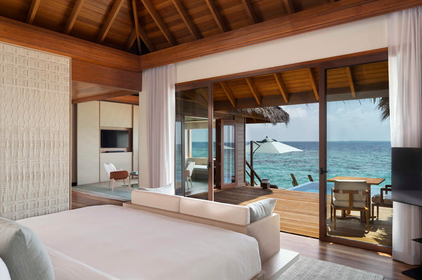 The bedroom of an Ocean Bungalow with Pool at Huvafen Fushi, doors open to the deck.