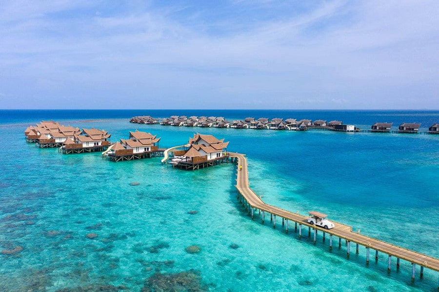 OZEN RESERVE Bolifushi from the air, thatched water villas branching off a jetty over the turquoise lagoon