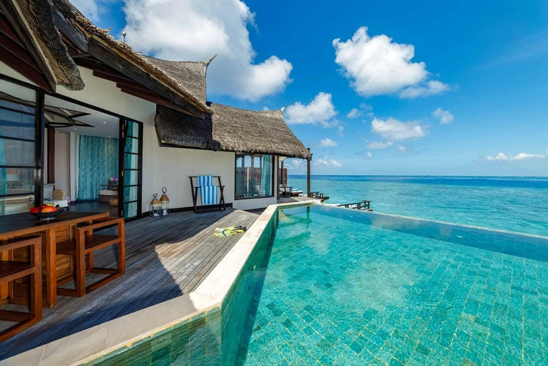 The deck of a water villa at OZEN RESERVE Bolifushi, its pool running to the edge of the lagoon