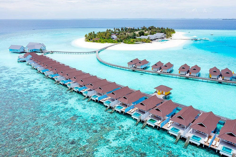 Water villas at The Standard Huruvalhi from the air, two rows on the jetty with the island behind.