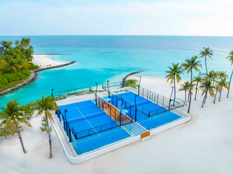The padel tennis courts at Hard Rock Hotel Maldives, seen from the air beside the lagoon.