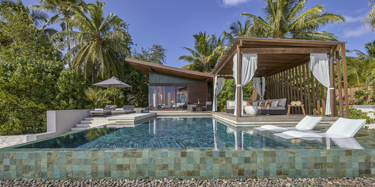 A villa pool and shaded pavilion at Park Hyatt Maldives Hadahaa, loungers along the water's edge
