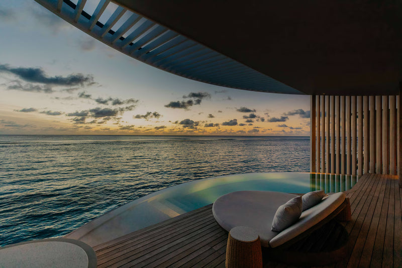 A villa plunge pool at The Ritz-Carlton Maldives Fari Islands, round daybed at sunset.