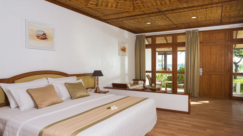 The bedroom of a Standard Beachfront Room at Bandos Maldives.