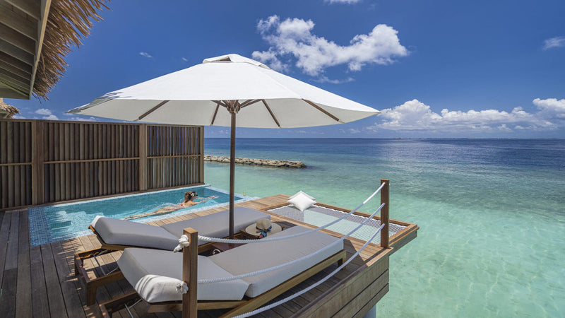 The deck and pool of a Sunset Water Villa at Bandos Maldives, looking out over the lagoon.