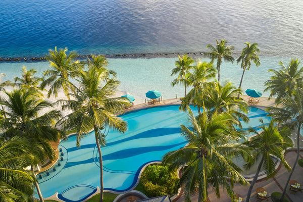 The main pool at Royal Island seen from above, edged with palms and loungers