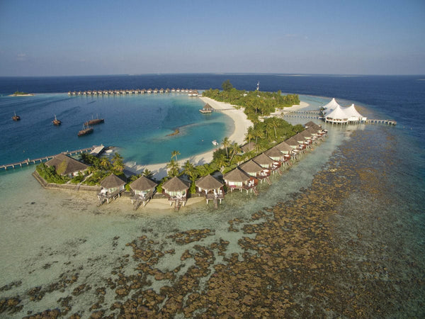 Safari Island from the air in North Ari Atoll, the reef running close around the island and bungalows along the shore
