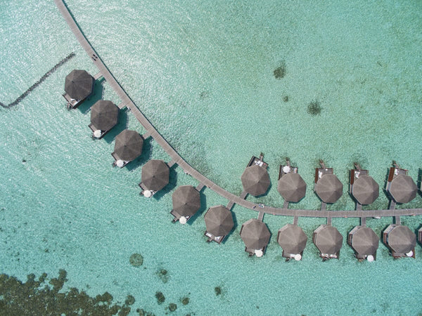 The curve of water bungalows on their walkway over the turquoise shallows at Safari Island
