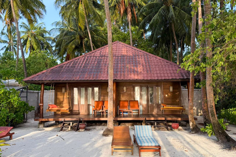 Exterior of a semi-detached beach villa among the palms at Medhufushi Island Resort