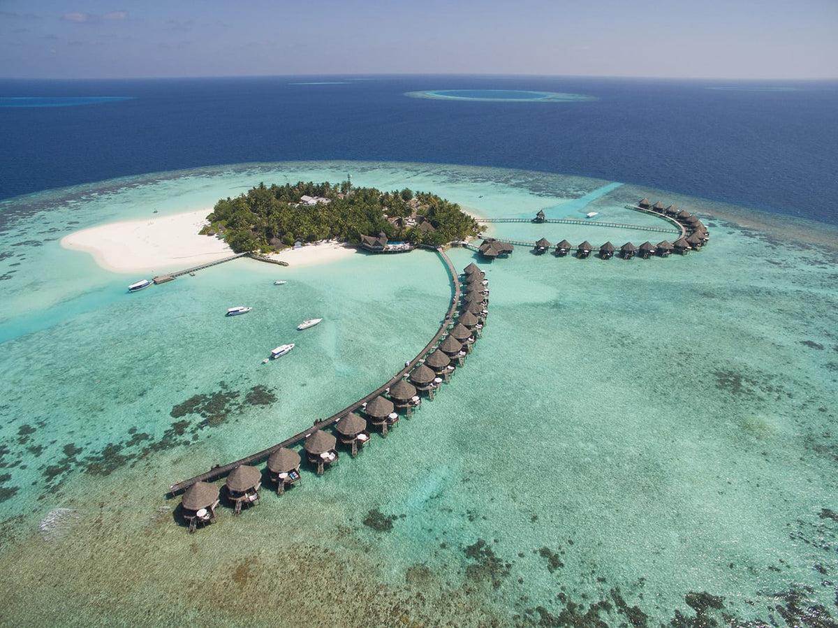 Thulhagiri Island Resort and Spa Maldives from the air, the island and its curving villa jetty.