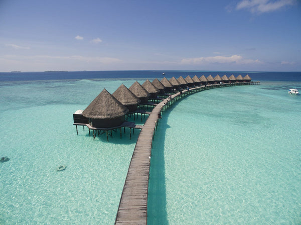 Water bungalows on their jetty over the turquoise lagoon at Thulhagiri Island Resort