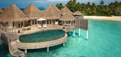 An Ocean House with Private Pool at The Nautilus Maldives, thatched pavilions and a curved pool above the lagoon.