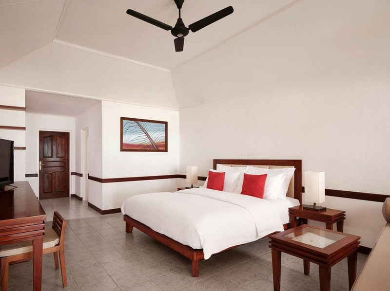 A twin bedded Beach Villa interior at Villa Nautica, framed artwork above dark timber furniture.