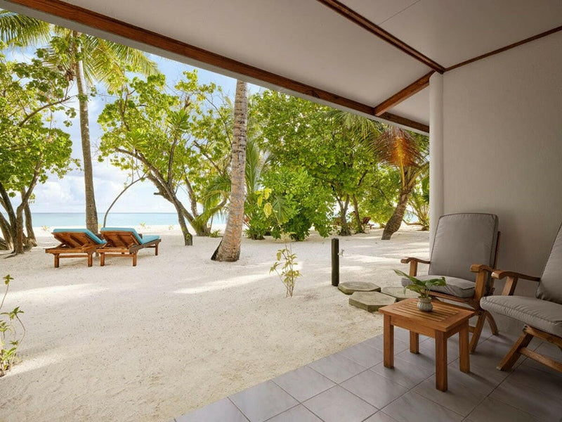 The view from a beach villa terrace at Villa Park Sun Island, loungers on the sand under the trees