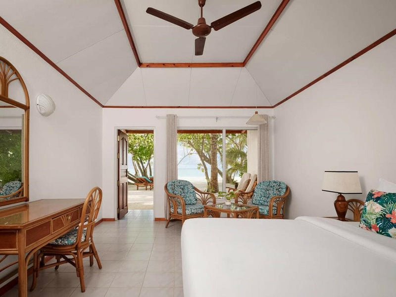 Inside a beach villa at Villa Park Sun Island, open doors framing the garden and the sand outside