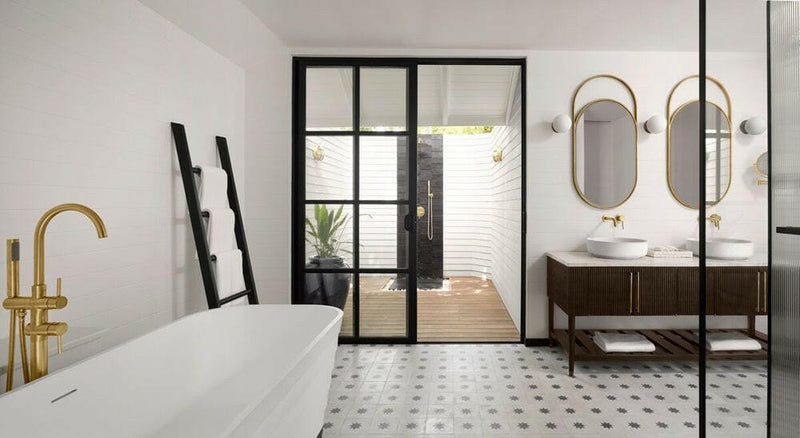 A villa bathroom at Villa Nautica, freestanding tub with a gold tap beside a glazed outdoor shower.