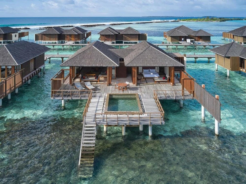 An ocean suite at Villa Nautica from above, a turquoise plunge pool set into its overwater deck.