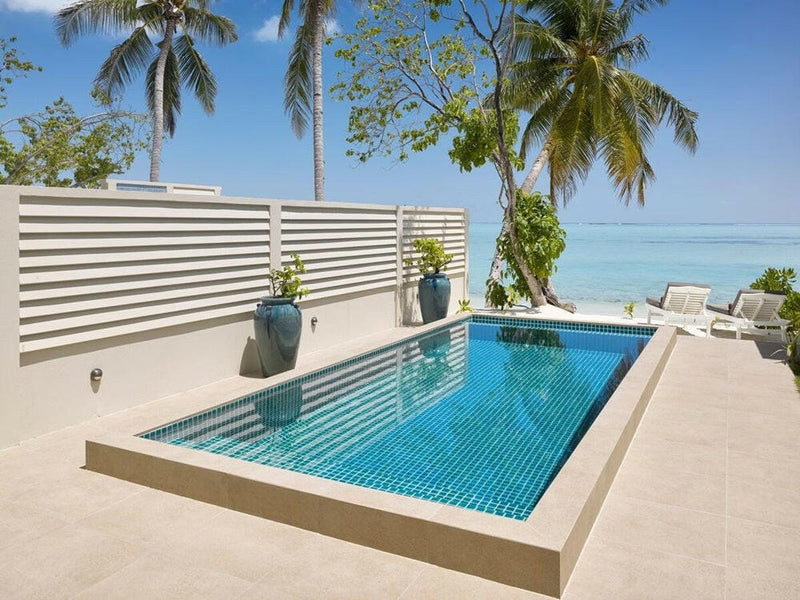 A private villa pool at Villa Park Sun Island, turquoise tiles behind a white slatted privacy screen