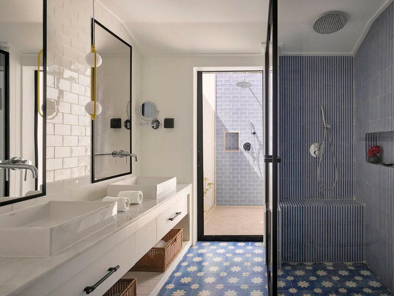 A villa bathroom at Villa Park Sun Island, twin basins under black framed mirrors on a patterned floor