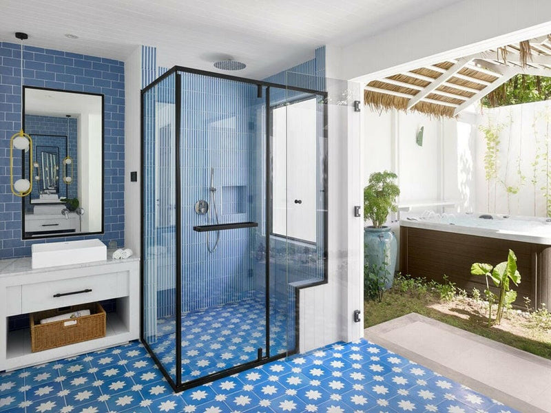 A villa bathroom at Villa Park Sun Island, a blue tiled shower cubicle and an outdoor tub in the courtyard