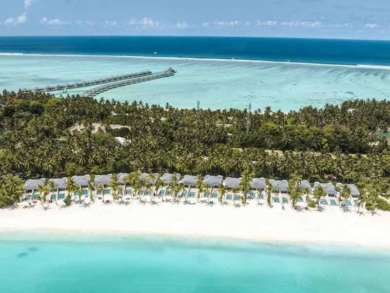 Villa Park Sun Island from the air, villas under the palms along the beach with the jetty beyond