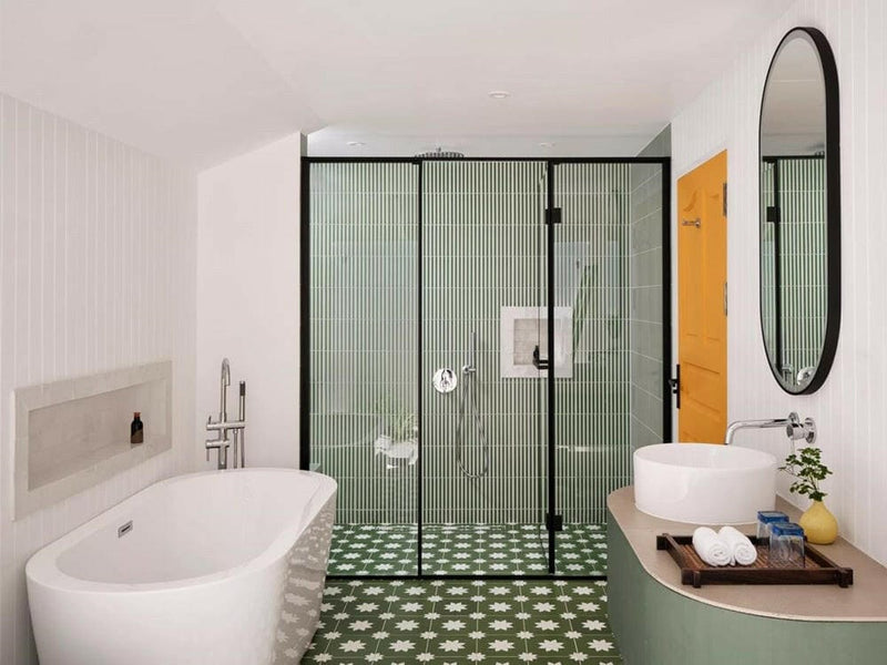 A villa bathroom at Villa Park Sun Island, a freestanding tub beside a green tiled walk-in shower