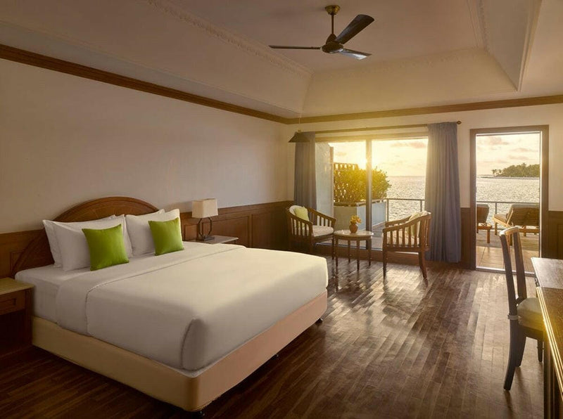 A water villa bedroom at Villa Park Sun Island, late afternoon light falling across the timber floor