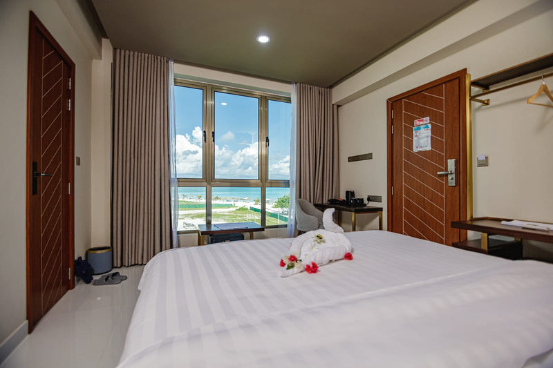 Room at Royal Villa with a double bed and a full-height window