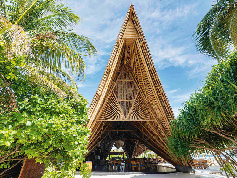 A bamboo pavilion among the palms at Kuredhivaru Resort & Spa Maldives.