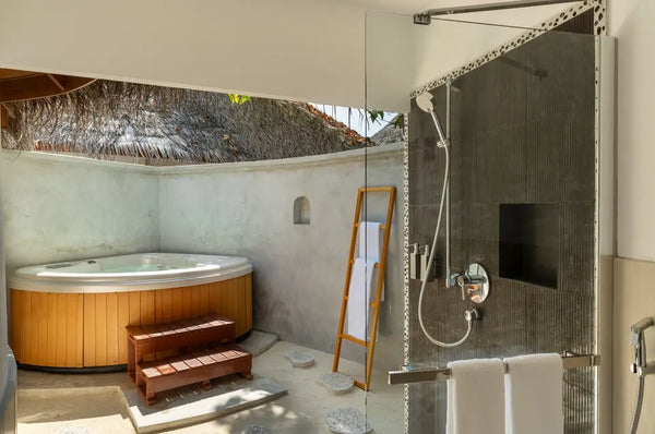 The bathroom of a Superior Beach Villa at Niva Kuramathi Maldives, looking out to the garden.