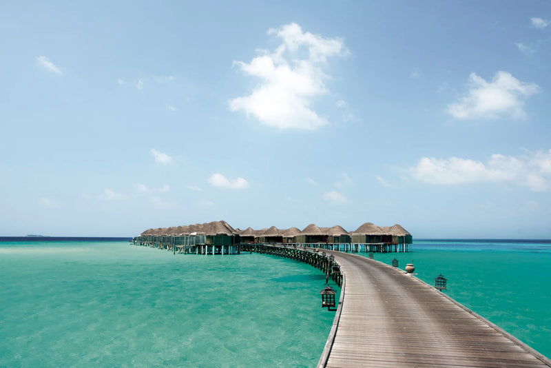 Constance Halaveli, North Ari Atoll: the long jetty of thatched Water Villas curving out over the turquoise lagoon