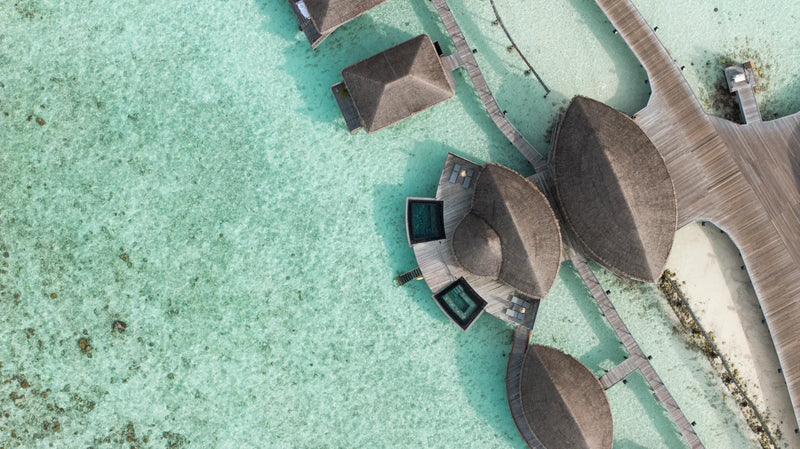 Constance Halaveli, North Ari Atoll: thatched overwater spa pavilions linked by walkways, seen from above