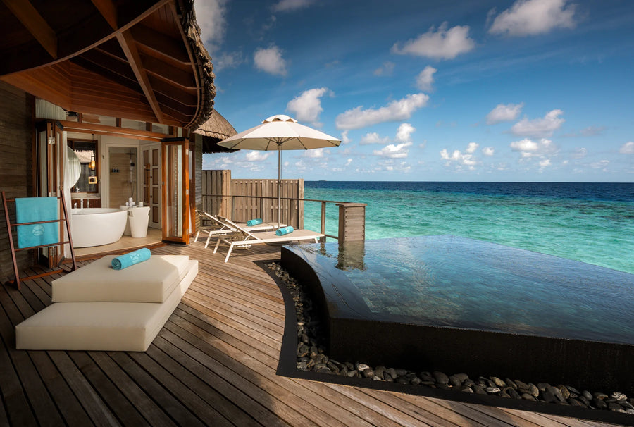 Constance Halaveli, North Ari Atoll: Water Villa deck with an infinity-edge plunge pool, daybed and umbrella facing the open sea