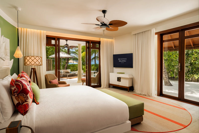 Constance Halaveli, North Ari Atoll: Beach Villa bedroom with French doors opening onto the garden