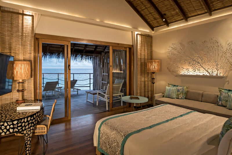 Constance Moofushi, South Ari Atoll: Water Villa bedroom with sliding doors open onto the deck and the sea