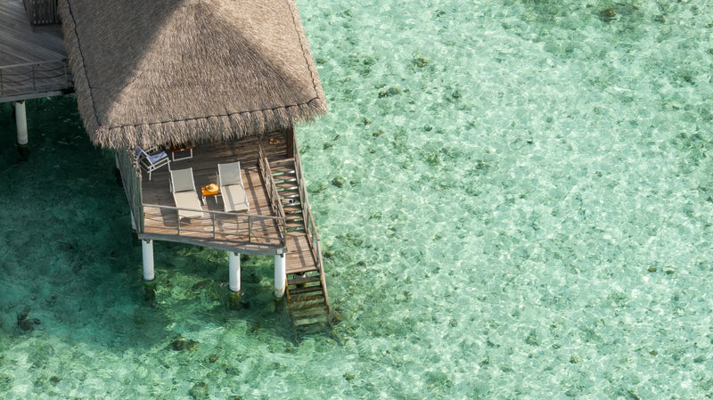 Constance Moofushi, South Ari Atoll: a Water Villa seen from above, its deck and steps leading down into clear water