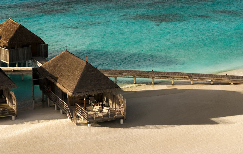 Constance Moofushi, South Ari Atoll: a thatched Senior Sand Villa raised on stilts at the edge of the beach, the lagoon beyond