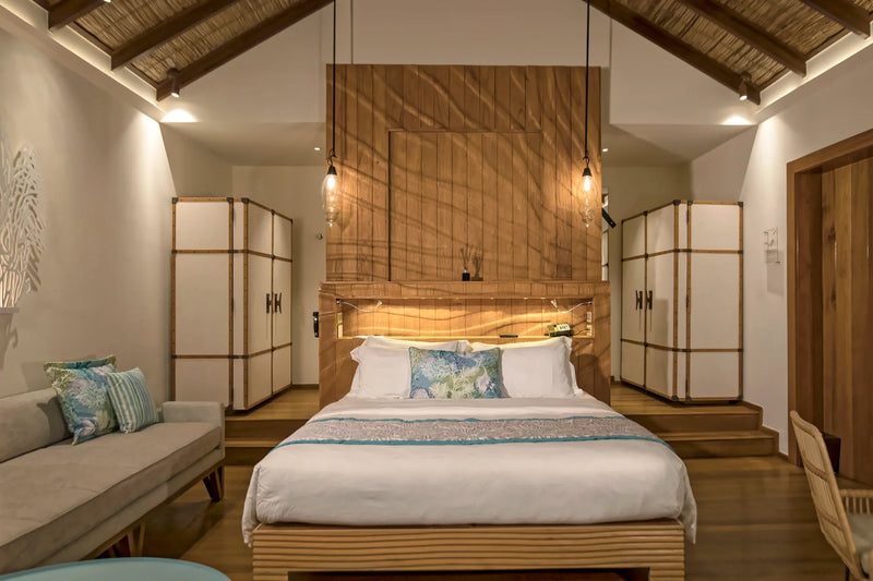 Constance Moofushi, South Ari Atoll: Sand Villa bedroom with a double bed, timber headboard wall and wardrobes either side