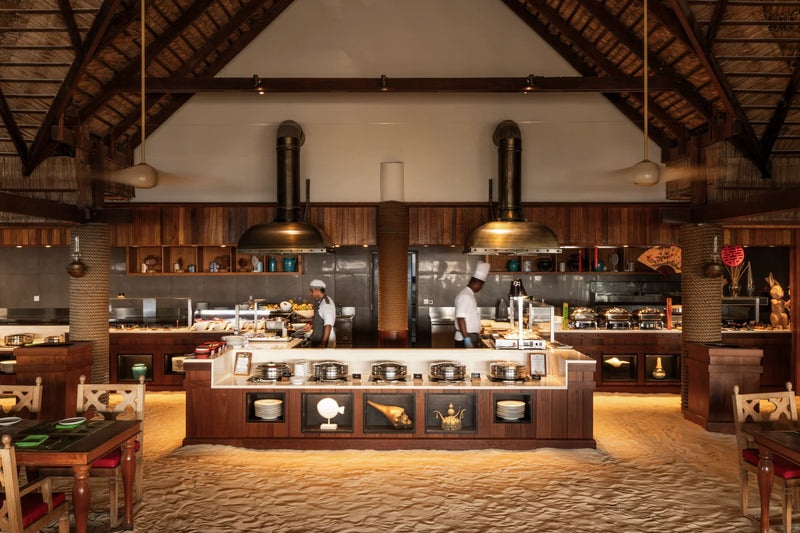 Constance Moofushi, South Ari Atoll: buffet stations and open kitchen in the main restaurant, sand underfoot