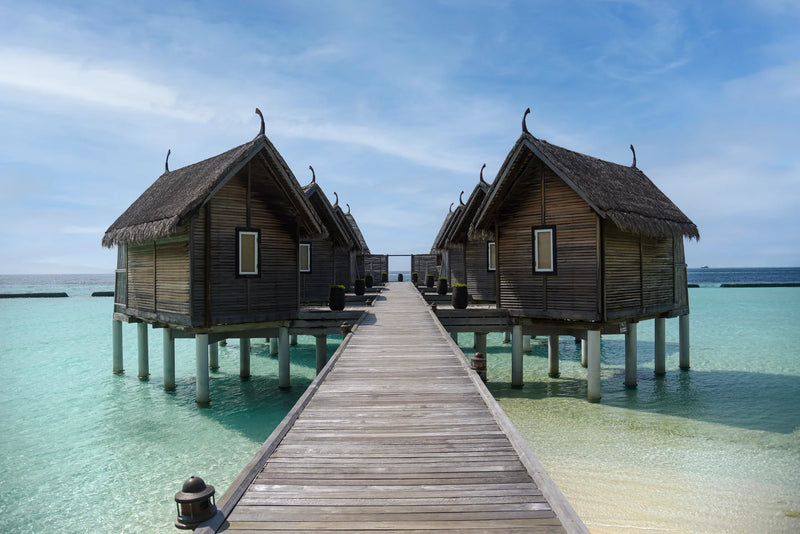 Constance Moofushi, South Ari Atoll: thatched spa treatment rooms on stilts either side of a jetty over the lagoon