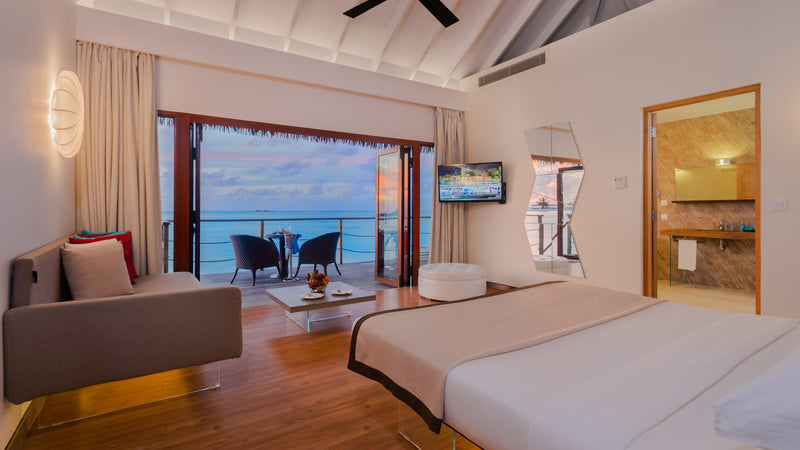 A bedroom opening to the sea at Cocoon Maldives.