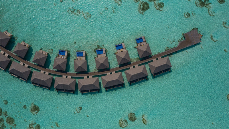 Loungers along the overwater walkway at Cocoon Maldives.