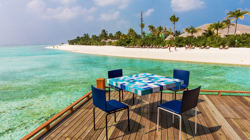 A table set over the water at Cocoon Maldives.