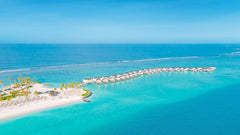 The beach and overwater villas along the lagoon at Joy Island Maldives.